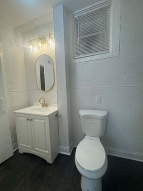 Louisville house for rent - A white toilet sits next to a sink in a small bathroom.