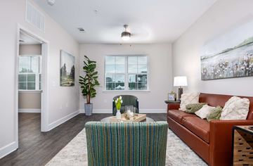 Macon apartment for rent - A living room with a brown couch and a green and blue patterned table.
