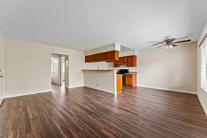 Burbank apartment for rent - A spacious room with wooden flooring and a ceiling fan.