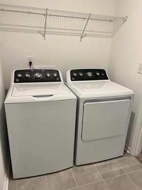 Charlotte house for rent - Two white front loading washing machines in a laundry room.