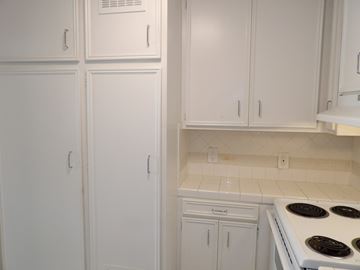 Dallas apartment for rent - A kitchen with white cabinets and a white stove top.
