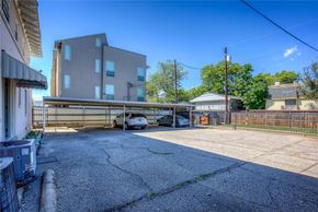 Dallas apartment for rent - A parking lot with a building and cars parked in front.