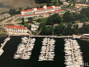 Portsmouth apartment for rent - A large white building with a red roof sits next to a marina filled with boats.