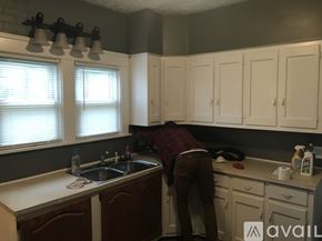 Warren house for rent - A person is cleaning a kitchen with a spray bottle.