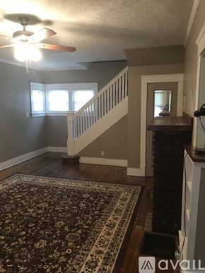 Warren house for rent - A living room with a rug, a ceiling fan, and a staircase.