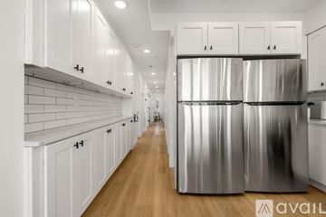 Boston apartment for rent - A modern kitchen with white cabinets and a large stainless steel refrigerator.