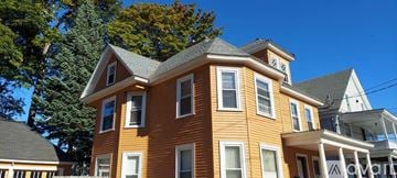 Rochester apartment for rent - A large two-story house with a brown exterior and white trim.