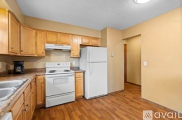 Rosemount apartment for rent - A kitchen with wooden cabinets and a white refrigerator.
