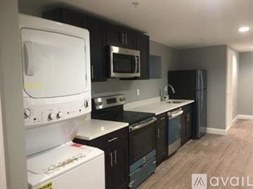 Boston apartment for rent - A kitchen with black cabinets and a white oven.