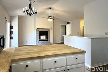 Bloomington house for rent - A kitchen with a wooden counter top and a chandelier hanging from the ceiling.