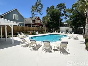 Santa Rosa Beach apartment for rent - A pool surrounded by chairs and a fence.