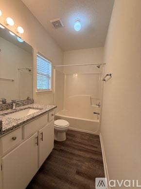 Santa Rosa Beach apartment for rent - A spacious room with wooden flooring and a ceiling fan.