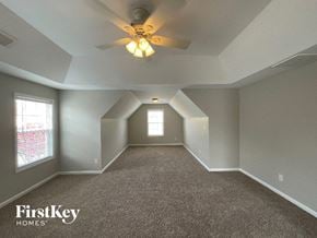 Clemmons house for rent - A spacious room with a carpeted floor and a ceiling fan.