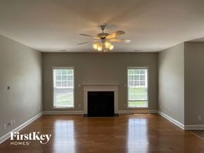 Clemmons house for rent - A spacious living room with a fireplace and a ceiling fan.