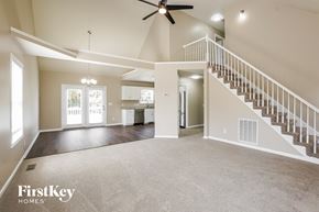 Clarksville house for rent - A spacious living room with a staircase leading to the upper floor.