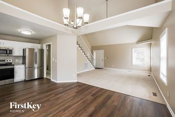 Clarksville house for rent - A spacious kitchen with a stainless steel refrigerator and oven, and a wooden floor.