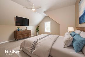 Clarksville house for rent - A bedroom with a bed, a ceiling fan, and a painting on the wall.