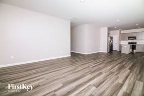 Four Oaks house for rent - A spacious room with wooden flooring and a kitchen area in the background.