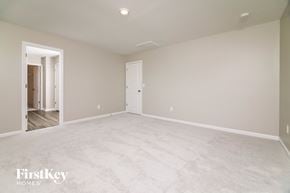 Four Oaks house for rent - A spacious empty room with a door on the right side.