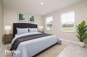 Four Oaks house for rent - A bedroom with a large bed, two lamps, and two pictures on the wall.