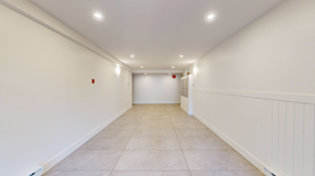 Victoria apartment for rent - A long, empty hallway with white walls and tiled flooring.