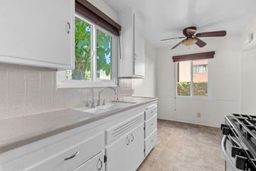 Burbank apartment for rent - A kitchen with white cabinets and a brown ceiling fan.