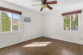 Burbank apartment for rent - A room with a ceiling fan and a window with a view of trees.