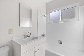 Burbank apartment for rent - A white bathroom with a sink, mirror, and bathtub.