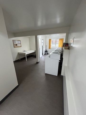 Victoria apartment for rent - A white kitchen with a table and chairs.