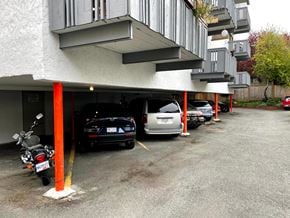Victoria apartment for rent - A parking lot with cars and a motorcycle.