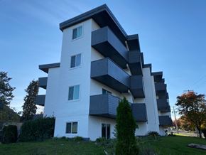 Victoria apartment for rent - A modern white and black building with balconies.
