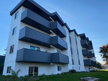 Victoria apartment for rent - A modern multi-story building with balconies and windows.