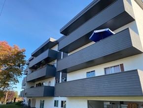 Victoria apartment for rent - A modern apartment building with balconies and a blue awning.