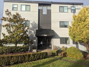 Victoria apartment for rent - A modern building with a black awning and the number 1194 on it.