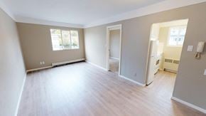 Victoria apartment for rent - A spacious empty room with a door and a window.