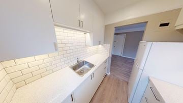 Victoria apartment for rent - A kitchen with white cabinets and a white sink.