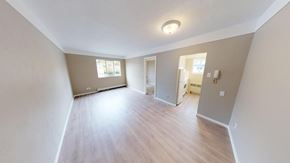 Victoria apartment for rent - A spacious room with wooden flooring and white walls.