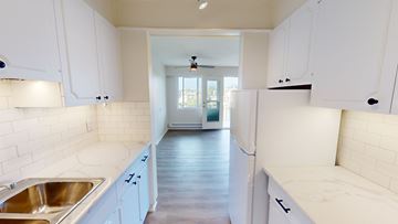 Victoria apartment for rent - A kitchen with white cabinets and a sink.
