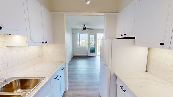 Victoria apartment for rent - A kitchen with white cabinets and a sink.