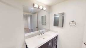 Victoria apartment for rent - A bathroom with a white sink and a mirror above it.