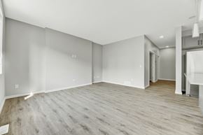 Edmonton apartment for rent - A spacious room with wooden flooring and white walls.