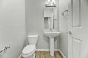 Edmonton apartment for rent - A white toilet sits next to a pedestal sink in a small bathroom.