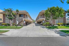 Burbank apartment for rent - A sunny day at a residential complex with two buildings on either side of a central driveway.