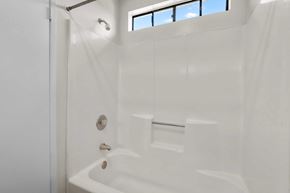 Burbank apartment for rent - A white bathroom with a tub and a window.