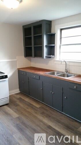 Baton Rouge apartment for rent - A kitchen with a white dishwasher and dark grey cabinets.