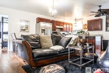 Goodlettsville house for rent - A living room with a black leather couch and a chandelier.
