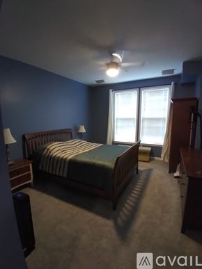 Aldie condo for rent - A bedroom with a bed, nightstand, and a ceiling fan.