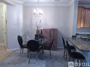Aldie condo for rent - A dining room with a table and chairs and boxes in the background.