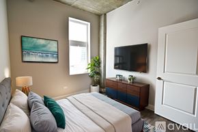 Chicago apartment for rent - A bedroom with a large bed and a painting on the wall.