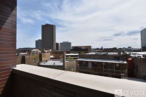 Chicago apartment for rent - A view from a balcony overlooking a cityscape with buildings of various heights.